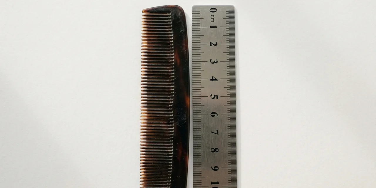 Pocket comb next to a steel ruler, measuring ~11 cm (110 mm)