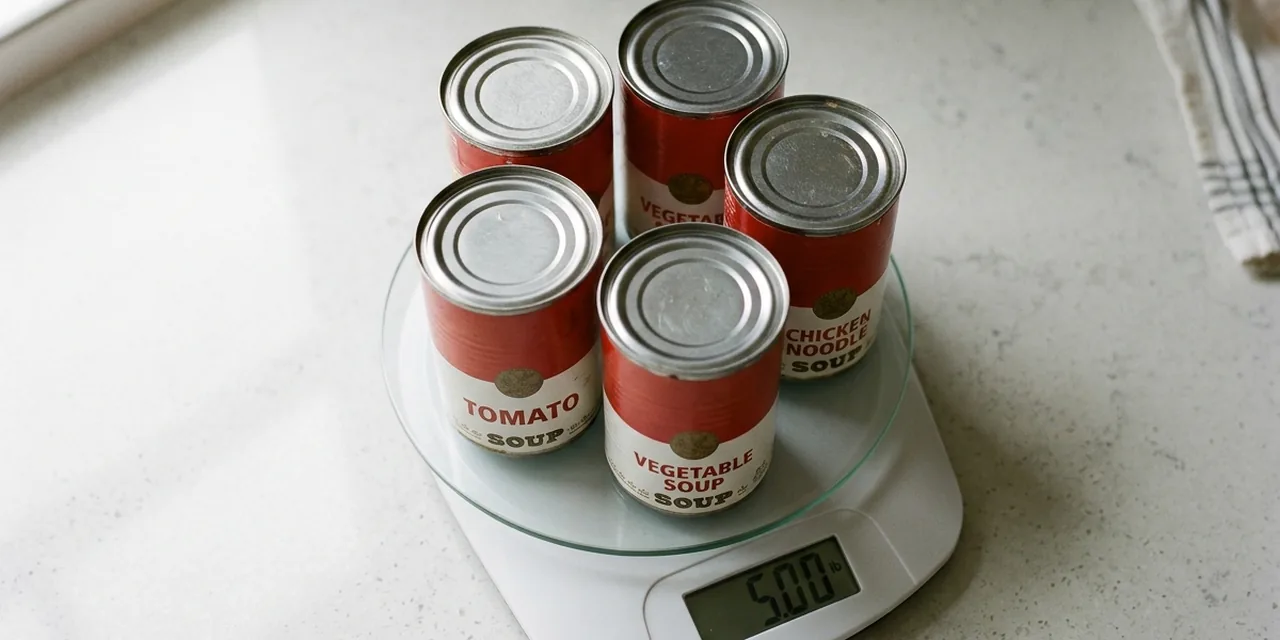 Five cans of soup on a kitchen scale reading ~5 lb (2.27 kg)